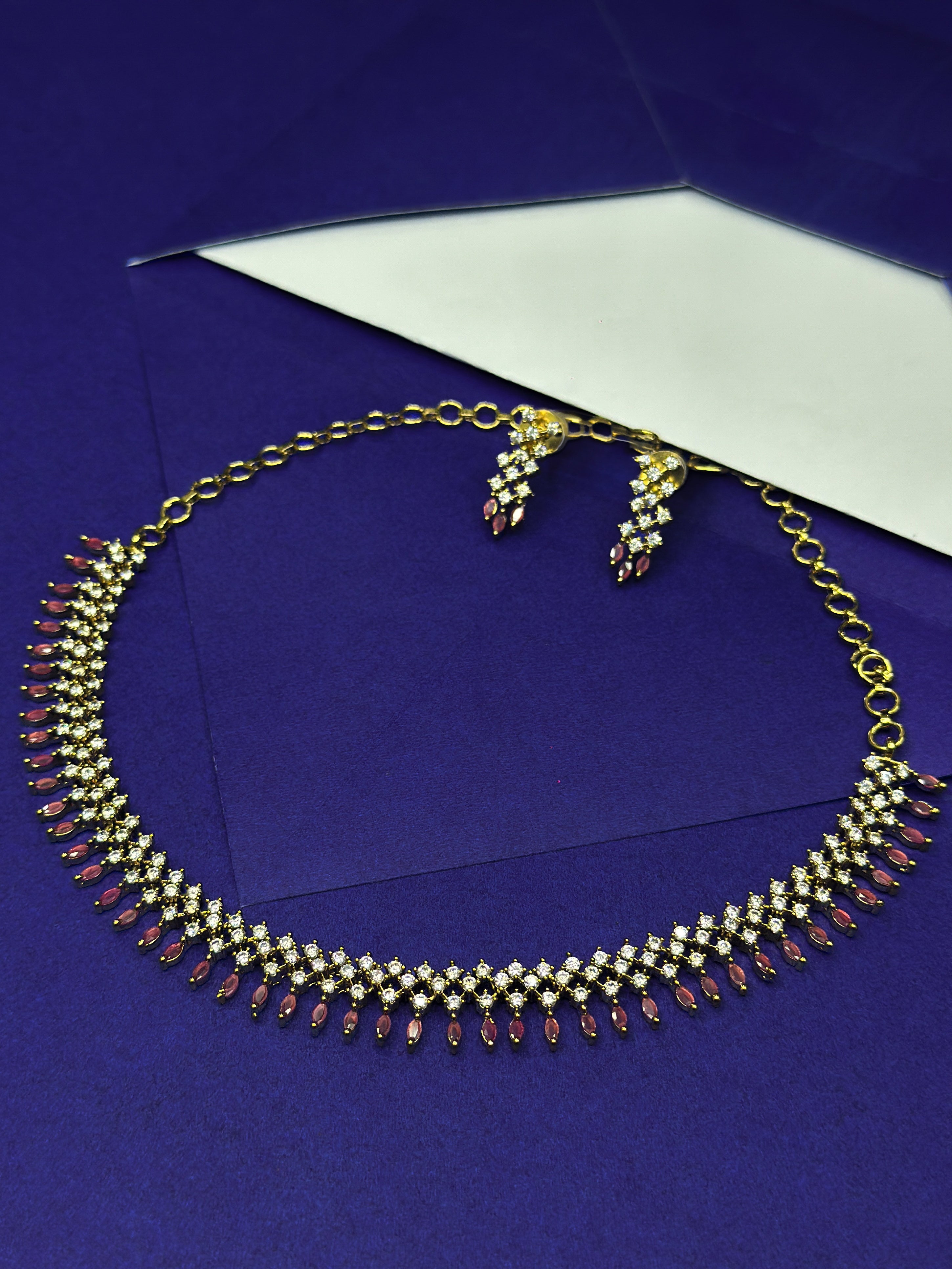AD Necklace with pink droppings  and earrings set on a blue background